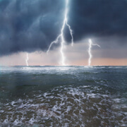 Three lightning strikes over ocean
