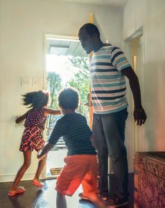 Father opening door to house leaving with son and daughter